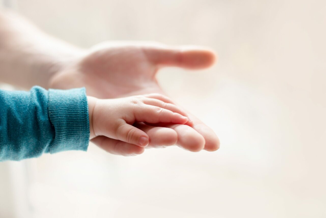 Parent holding the hand of a small child