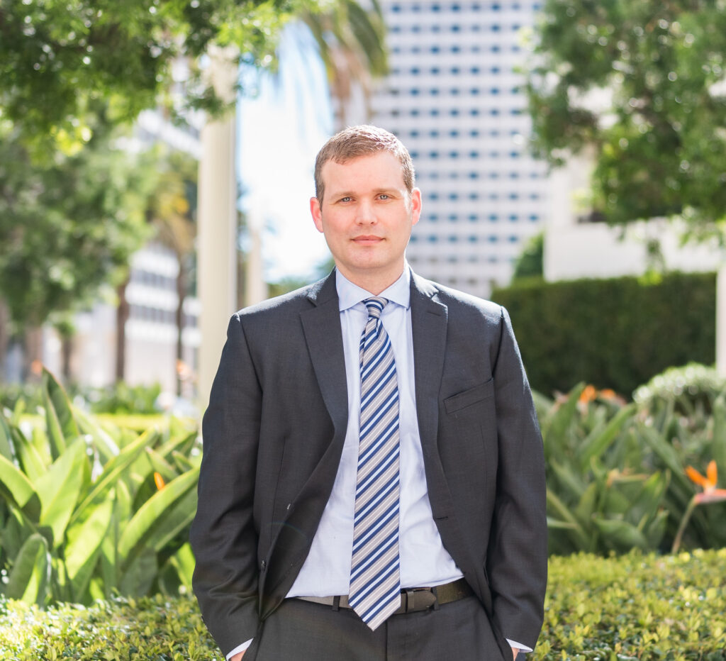 Lawyer wearing suit outside in front of building and shrubs