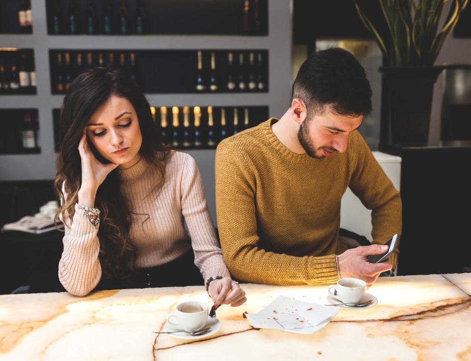 consequences of divorce - couple sits at table not looking at each other